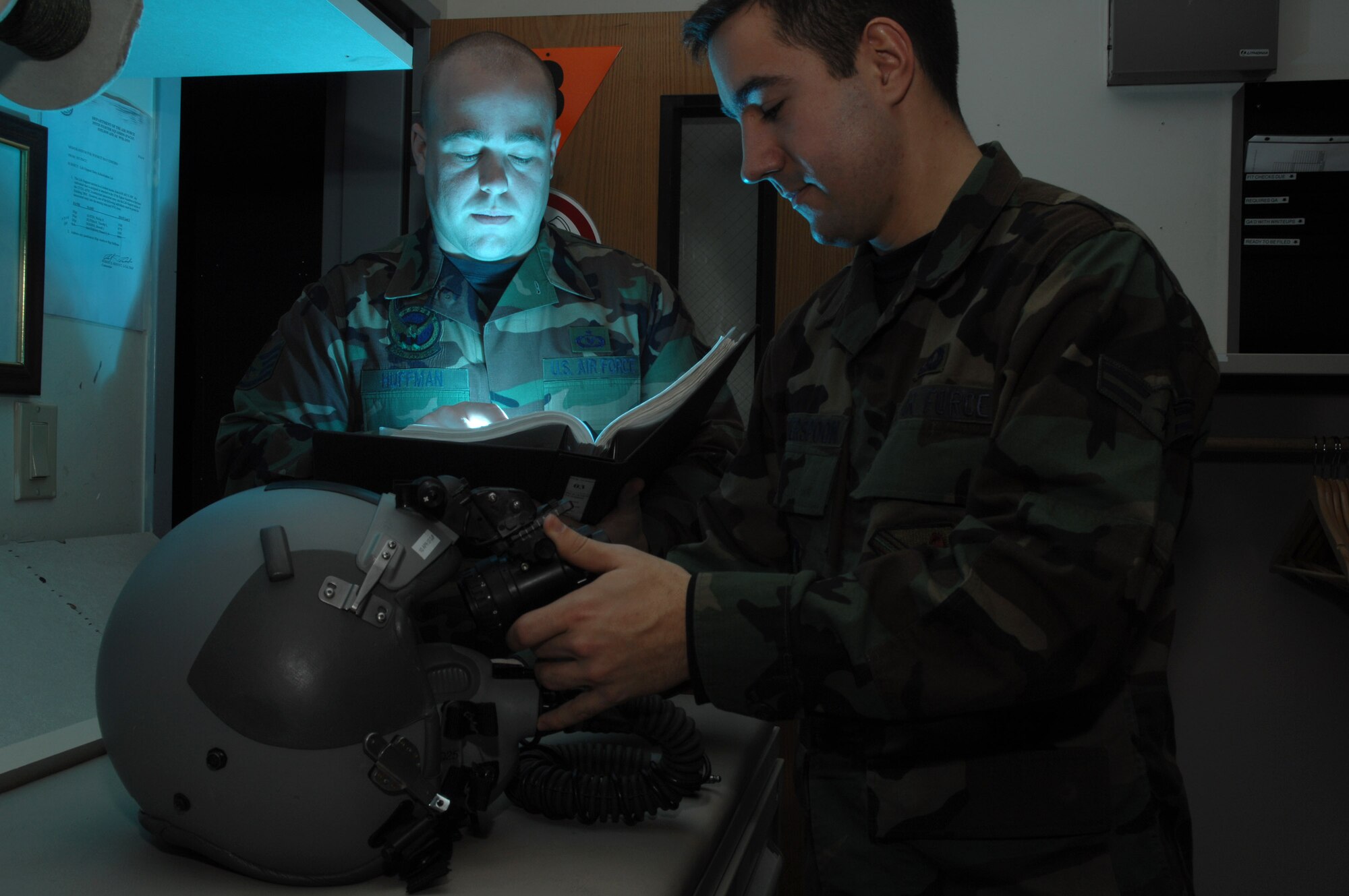 Airman 1st Class Andrew Witherspoon (right) adjusts the eyespan on a pair of AS/AVS-9 Night Vision Goggles while Staff Sgt. Timothy Huffman consults the technical order in the life support section of the 355th Fighter Squadron Nov. 29 at Eielson Air Force Base, Alaska. During the winter months, pilots at Eielson AFB are given a greater opportunity to train with NVG's more than their counterparts in the lower 48 states due to the decreased length of sunlight. (U.S. Air Force photo/Staff Sgt. Joshua Strang) 
