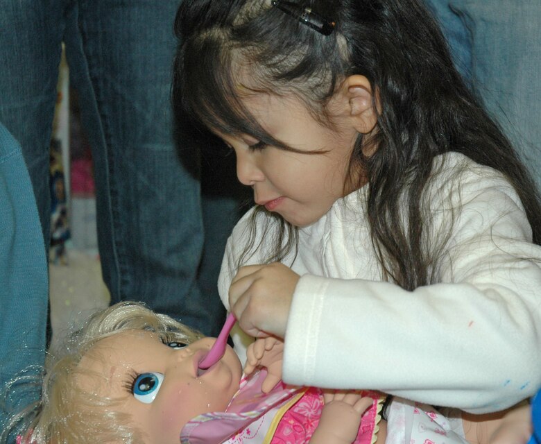 EIELSON AIR FORCE BASE -- Kaelani Hess, daughter of Staff Sgt. Erika hess, 354th Medical Support Squadron, feeds a baby doll during the Top of the World Toy Summit Nov. 29 at the Santa Claus House in North Pole, Alaska. More than 30 children were selected for the first-ever Top of the World Toy Summit spearheaded by Operation Homefront. (U.S. Air Force photo by Senior Airman Justin Weaver). 