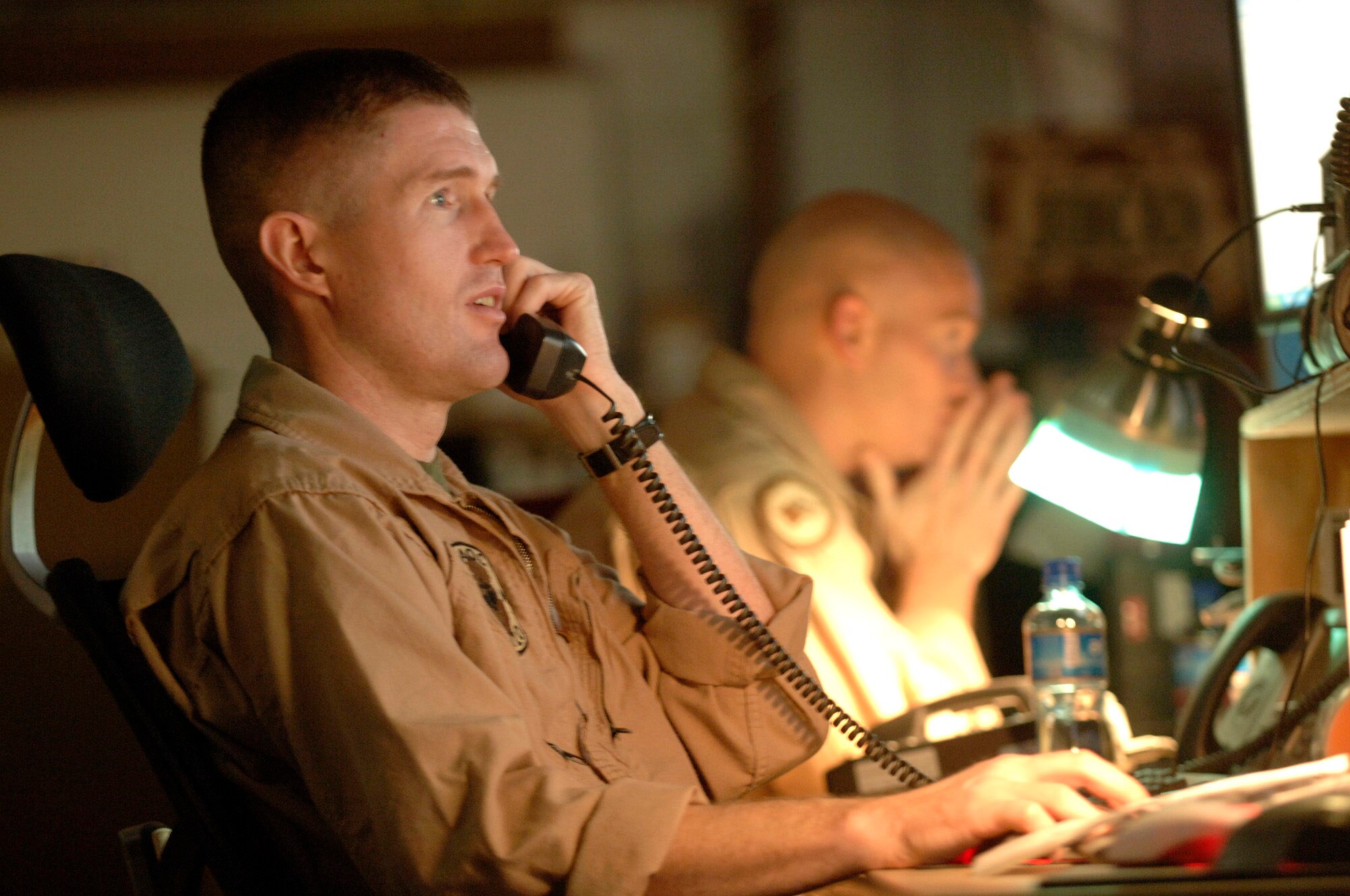 Inside the Combined Air Operations Center, Marine Capt. Jason Torbensen coordinates with an Air Force tanker unit downrange to arrange air refueling for a Marine Harrier aircraft flying a mission Nov. 25 over Iraq. Captain Torbensen is deployed for one year in Southwest Asia as the 3rd Marine Airlift Wing's liaison officer to the CAOC. (U.S. Air Force photo/Master Sgt. Scott Wagers) 