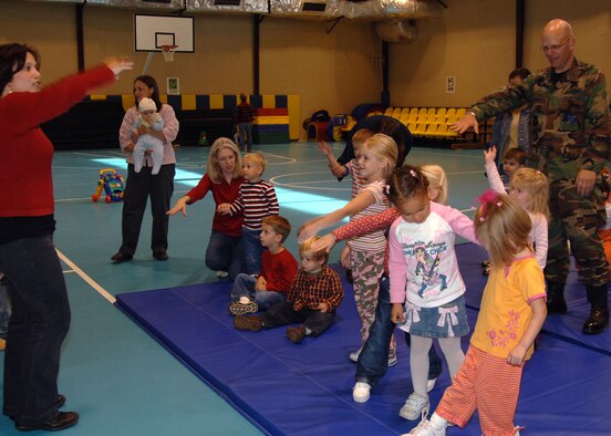 Carly Jones leads the way as Col. Murrell "Tip" Stinnette, (right) 39th Air Base Wing commander, dances to the "hokey pokey" with the children of the preschool playgroup at the base Youth Center, following a volunteer appreciation ceremony, Nov. 28. (U.S. Air Force photo by Airman Kelly L. LeGuillon) 