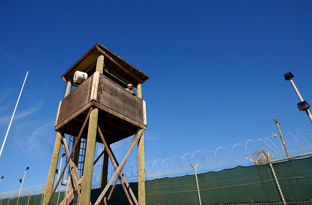 A U.S. Army soldier with Echo Company, 629th Military Intelligence Battalion, keeps watch from a guard tower at the Joint Task Force Guantanamo detention center on Naval Base Guantanamo Bay, Cuba, Nov. 13, 2006. The company's main missions, as part of the task force, include perimeter security as well as acting as a quick reaction force should something happen inside the detention center.