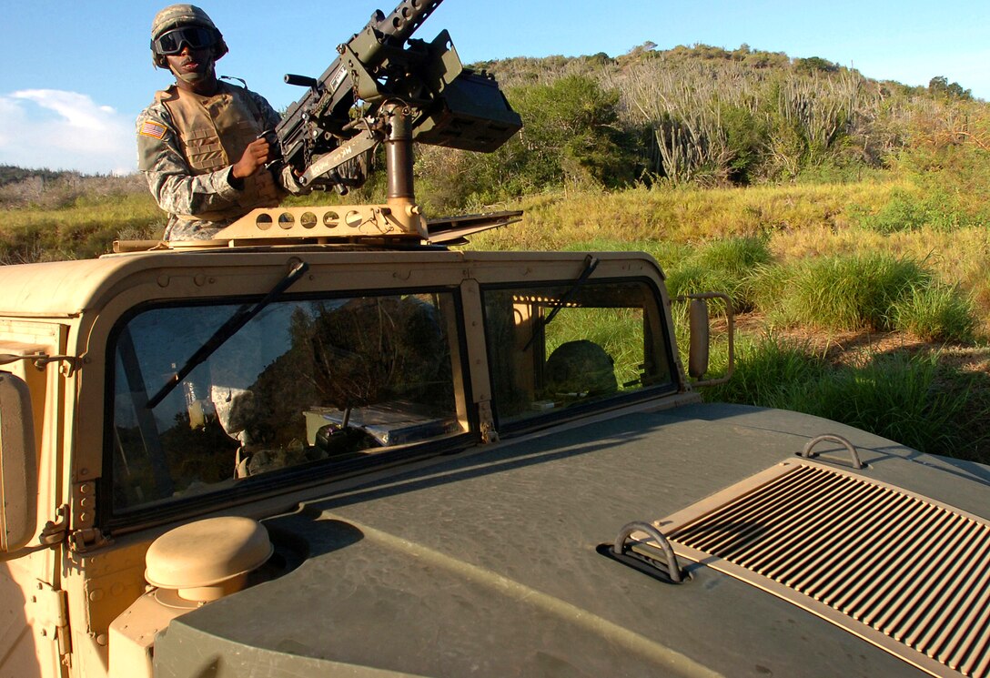 A U.S. Army soldier assigned to Echo Company, 629th Military Intelligence Battalion, provides overwatch security at a checkpoint area near the Joint Task Force Guantanamo detention center on Naval Base Guantanamo Bay, Cuba, Nov. 17, 2006. The company's main missions, as part of the task force, include perimeter security as well as acting as a quick reaction force should something happen inside the detention center.