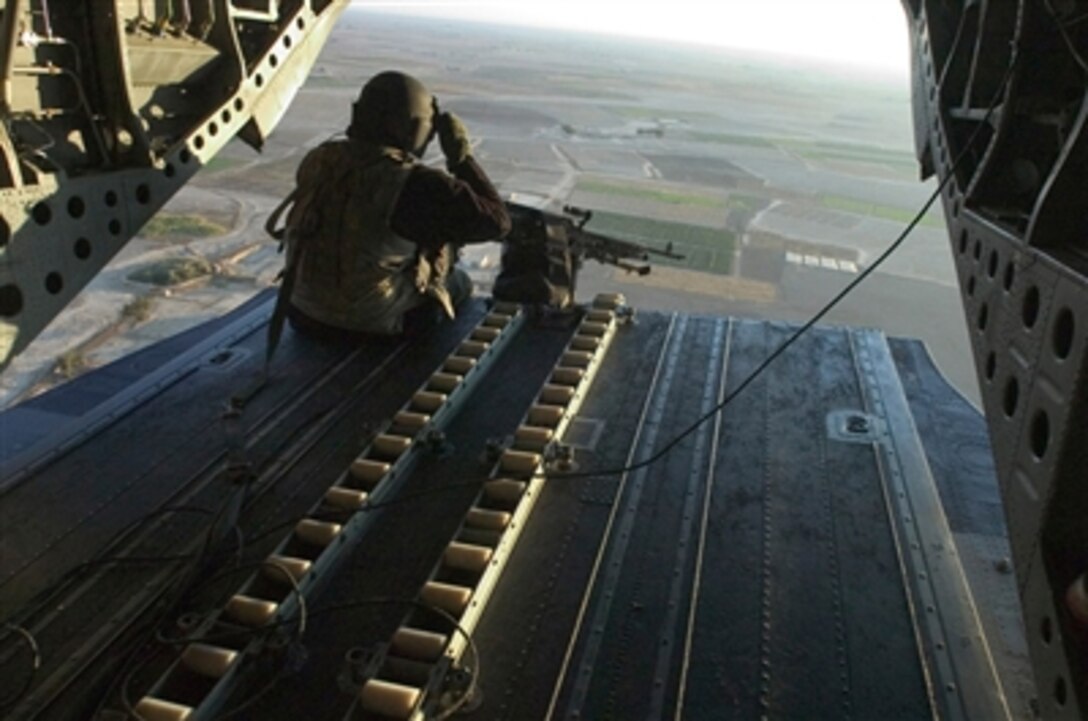 U.S. Army Sgt. Christopher Calloway adjusts his helmet visor as he mans a weapon in a CH-47 Chinook helicopter during a flight over Salah Ad Din province, Iraq, on Nov. 16, 2006.  Calloway is a flight engineer with Bravo Company, 25th Aviation Brigade, 25th Infantry Division.  