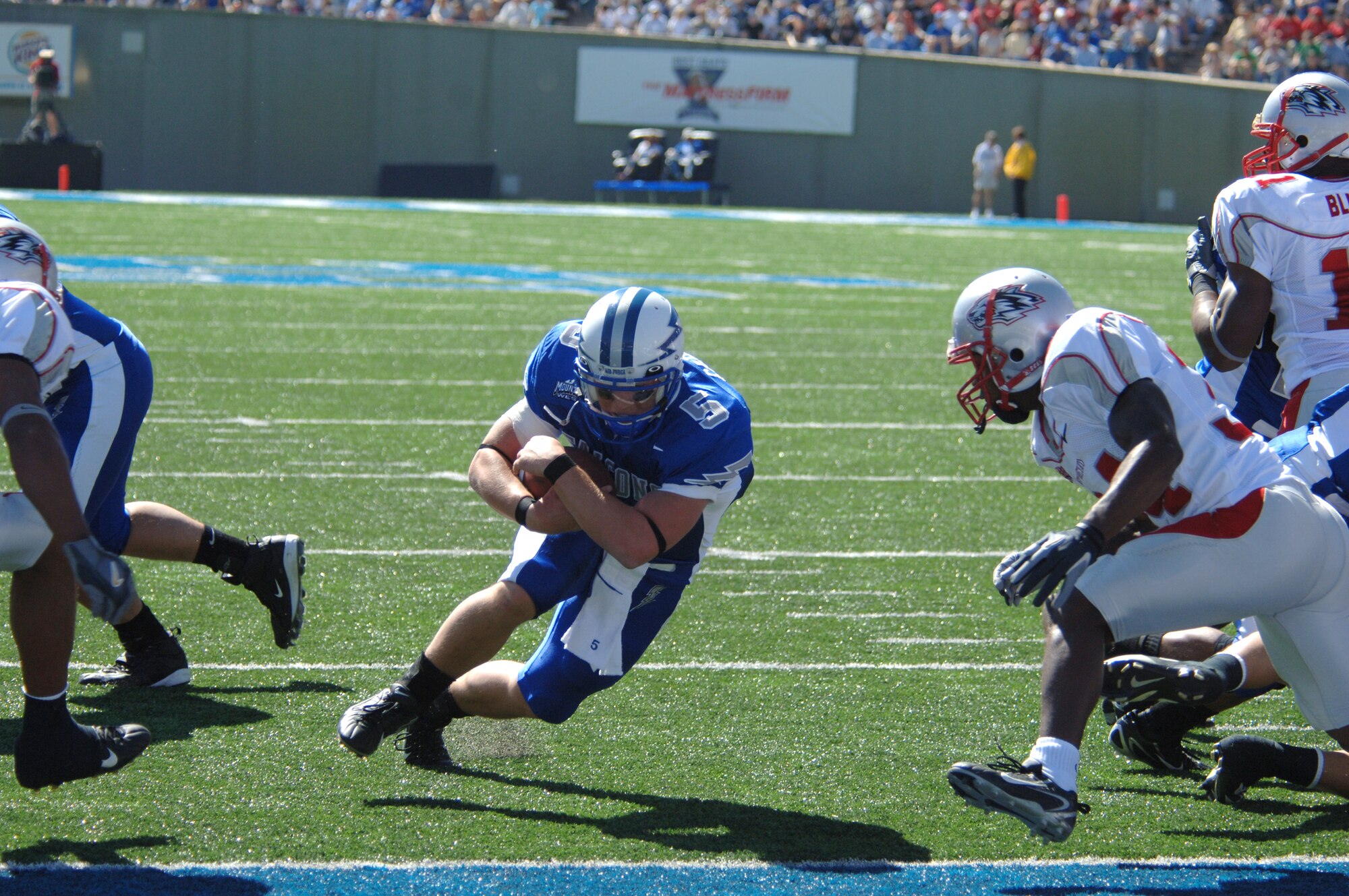 Air Force quarterback Shaun Carney dives into the end zone Sept. 30 to put the Falcons up 7-0. The Falcons went on to beat New Mexico 24-7 at home and improve their record to 2-1 overall and 2-0 in the Mountain West Conference. Air Force hosts Navy Oct. 7, in the first of two battles against service academy rivals, which will determine the Commander in Chief's Trophy recipient. (U.S. Air Force photo/John Van Winkle)