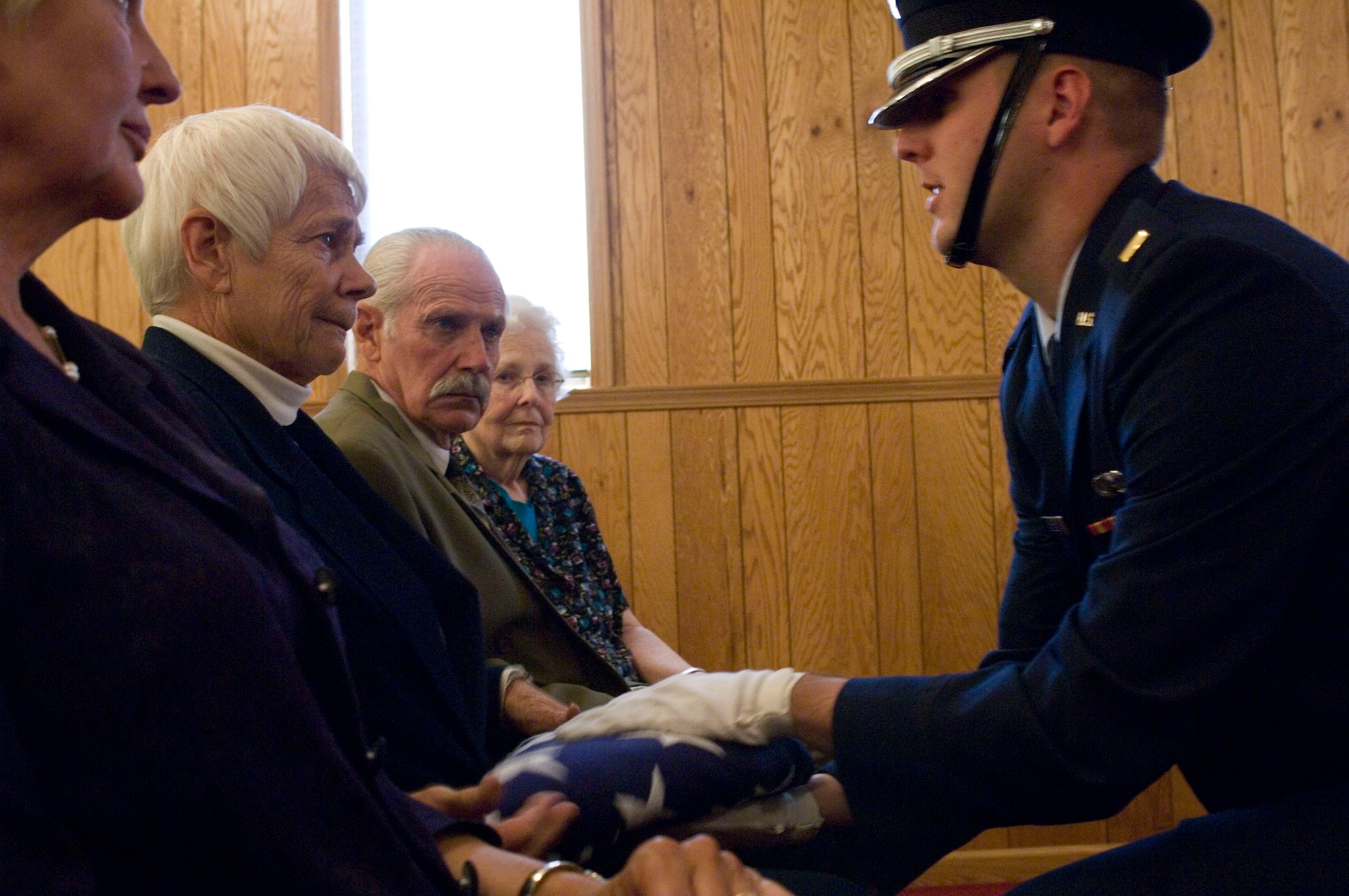 Martha Sweney, accompanied by her brother and sisters, receives the U.S. flag at her brother's memorial service Oct. 1 near Avon, Ill. Her older brother, 1st Lt. Bruce Sweney, was an Air Force pilot shot down over North Korea in 1951. He is one of 389 still listed as missing in action from the Korean War. (U.S. Air Force photo/Master Sgt. Jack Braden)