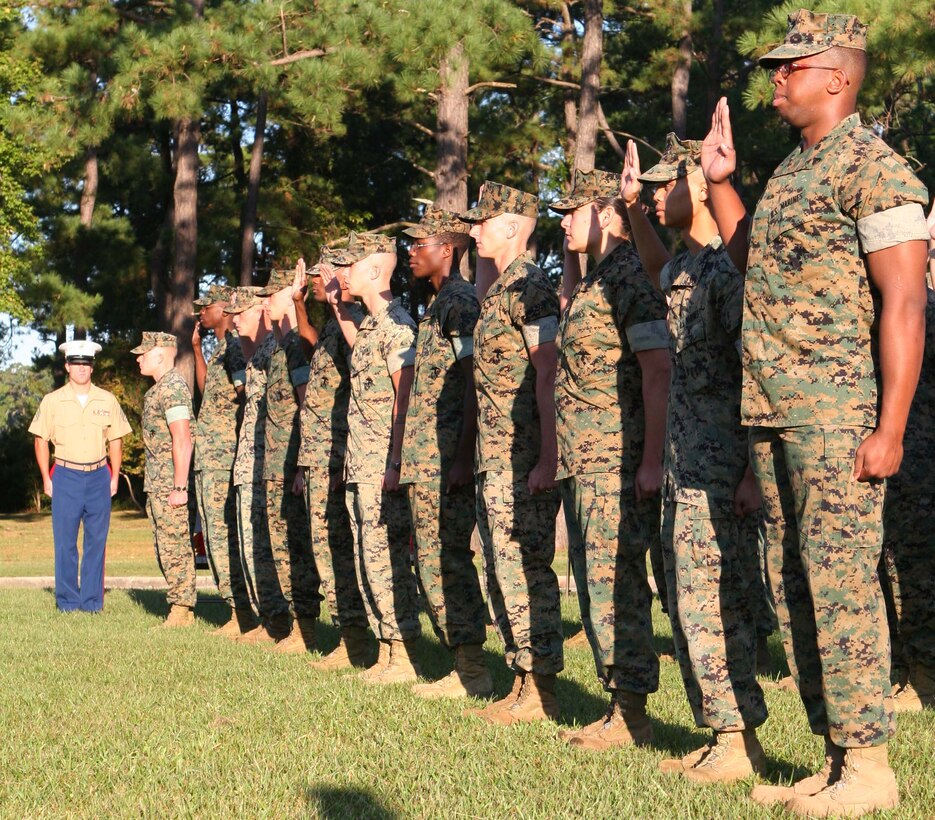 MARINE CORPS BASE CAMP LEJEUNE, N.C. ? Thirty-two Marines from 8th Communications Battalion, II Marine Expeditionary Force Headquarters Group, II MEF, raise their right hands as they recite the Oath of Enlistment during a mass re-enlistment ceremony, Oct. 2. The ceremony marks a milestone for the first-term Marines who decided to stay in the Corps. Many received different incentives and even lateral moves into different military occupational specialties.