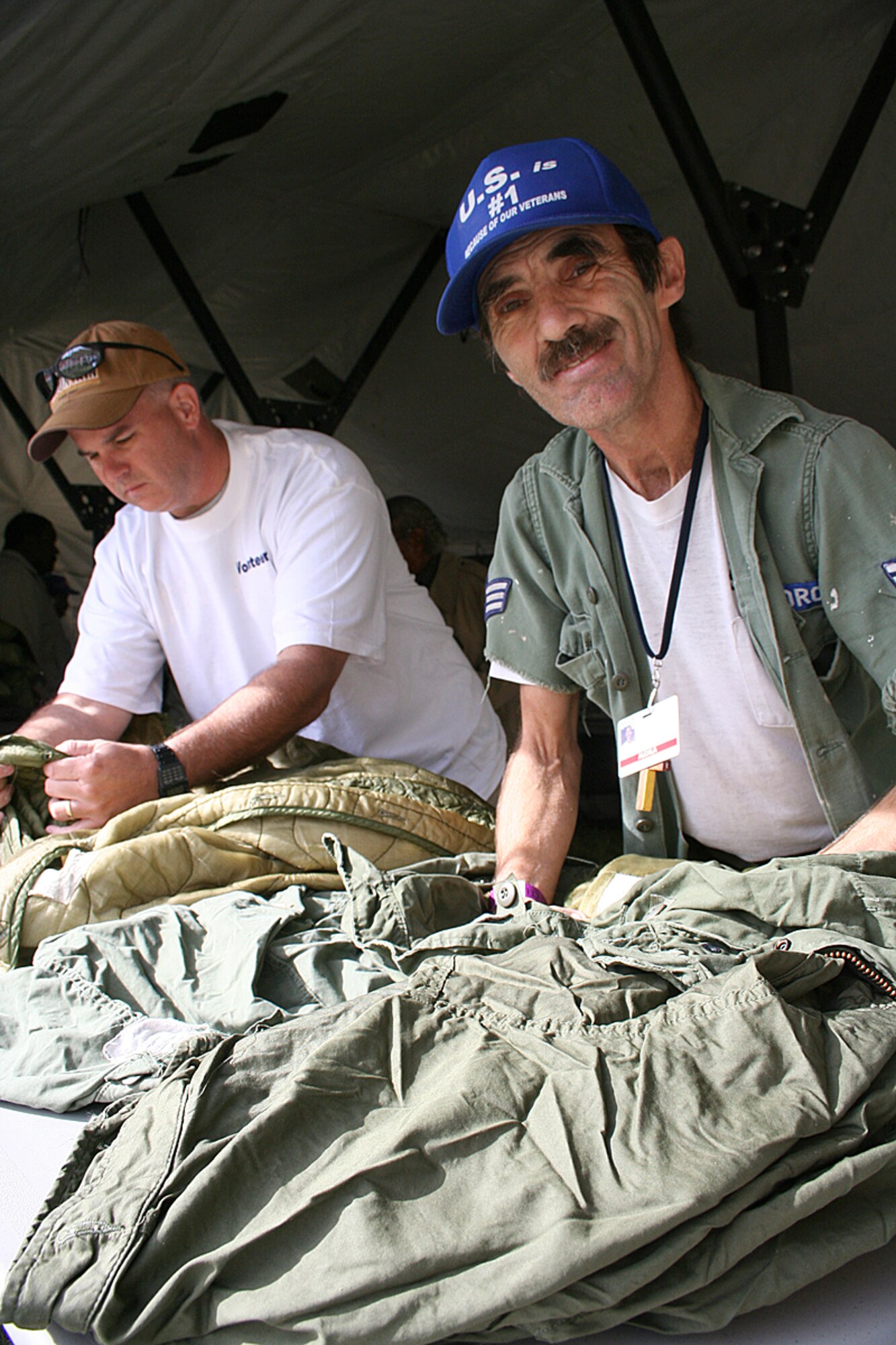 A six year Vietnam era veteran proudly displays his status as a veteran by his hat, "US is #1 because of our veterans." A member from MAFB helps others find the size jacket they are looking for. Photo by Petty Officer 2nd Class Troy Karr
