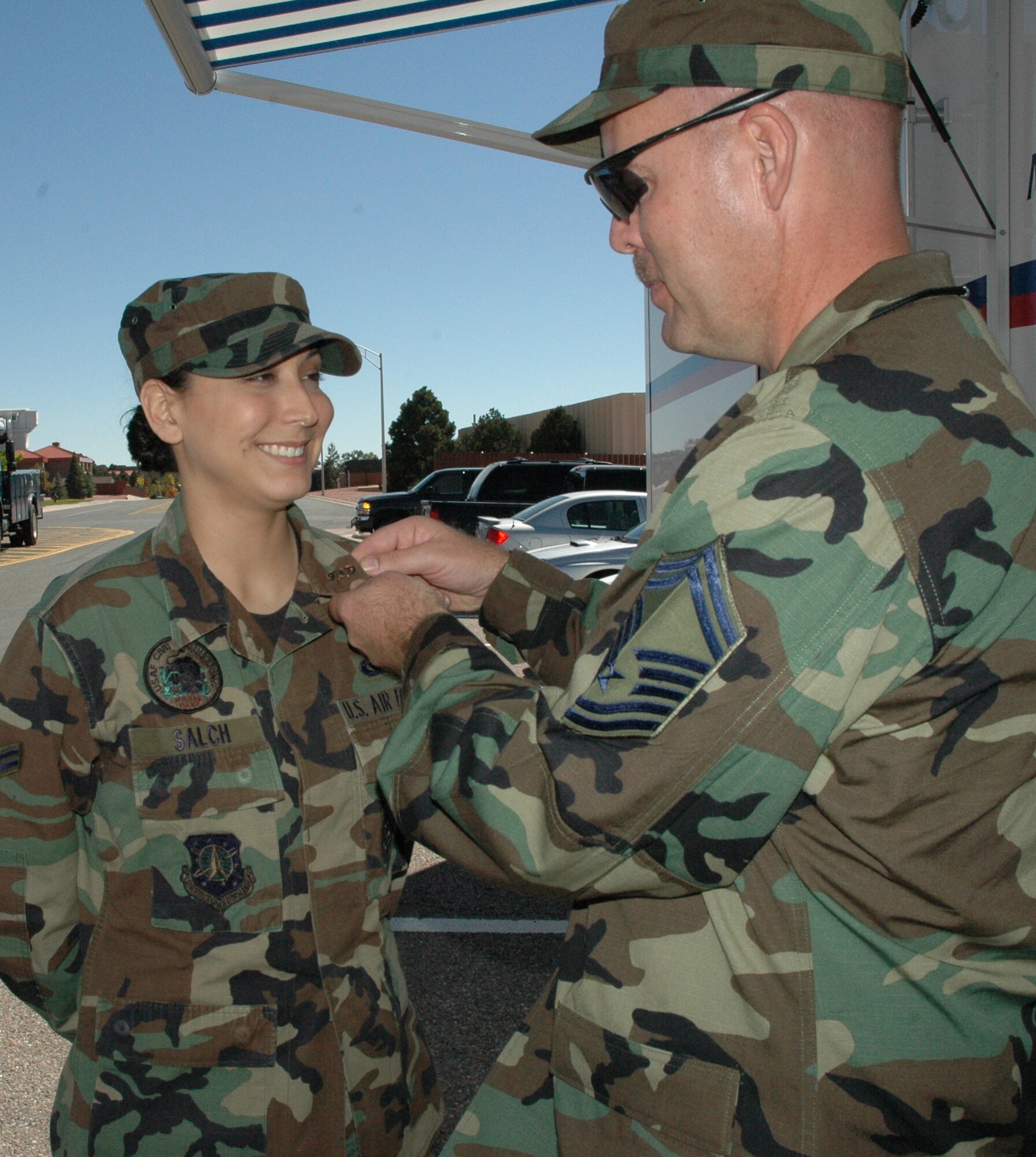 Senior Master Sgt. Mark Onken, Headquarters Air Force Space Command emergency management, pins one of the first organizational badges for the Chemical, Biological, Radiological, Nuclear and Explosive professionals on Airman 1st Class Lisa Salch, 21st Civil Engineer Squadron CBRNE professional, Sept. 29. The new organizational badge was approved by  Gen. T. Michael Moseley, Air Force Chief of Staff, Feb. 7 with the approved wear date of Oct. 1. (U.S. Air Force Photo by Senior Airman Jessica Switzer)