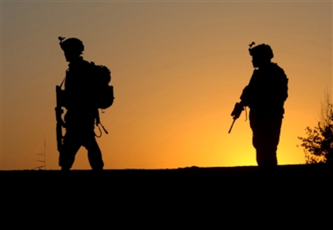 U.S. Army soldiers, assigned to 1st Battalion, 66th Armored Regiment, patrol a road at sunset during a cordon and search operation in Sheik Hamid, Iraq, Sept. 28, 2006, to gain information on terrorists cells operating in the area. 