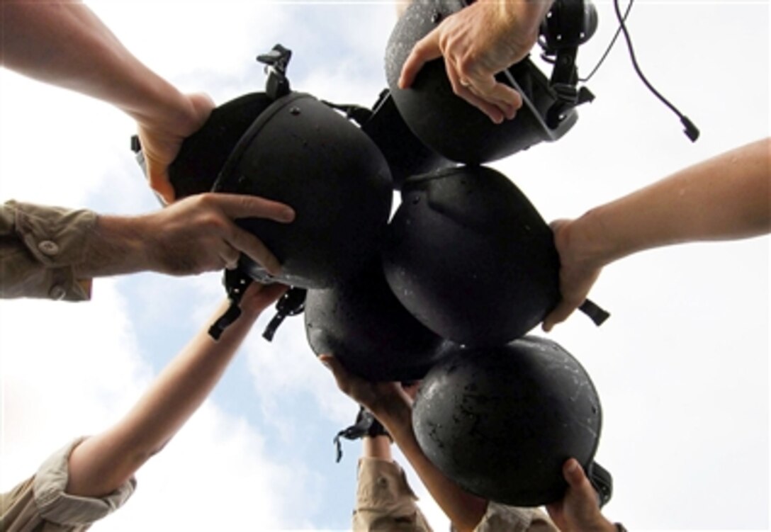 Members of the visit, board, search and seizure team from the Aegis-class destroyer USS Paul Hamilton clash their helmets together after a successful return from boarding a civilian ship for a search and seizure exercise, Sept. 27, 2006. 