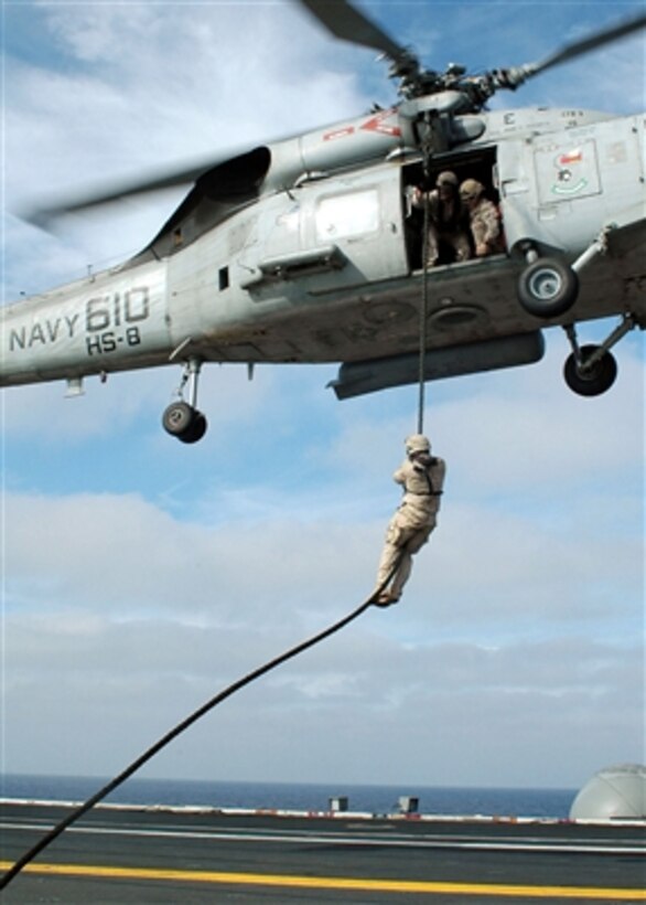 A U.S. Navy Explosive Ordnance Disposalman does a fast rope descent from an SH-60F Seahawk helicopter onto the flight deck of the nuclear-powered aircraft carrier USS John C. Stennis (CVN 74) on Sept. 28, 2006.  The Stennis is under way participating in a composite training unit exercise in the Pacific Ocean.  