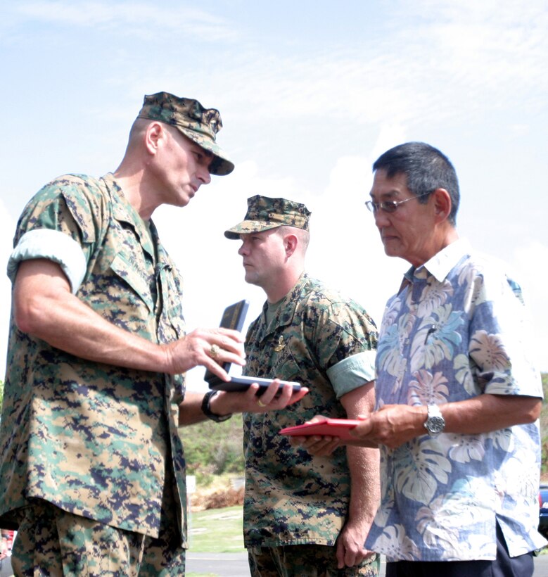 Col. Mark A. Dungan, deputy commander, MCBH, presents the Bronze Star Medal Oct. 3, to Richard Tsue, father of Staff Sgt. Daniel Tsue, and explosive ordnance disposal technician who was killed in action last year while supporting Operation Iraqi Freedom.  Tsue was killed Nov. 1st 2005, when responding to a request to neutralize a roadside bome in Ramadi.
