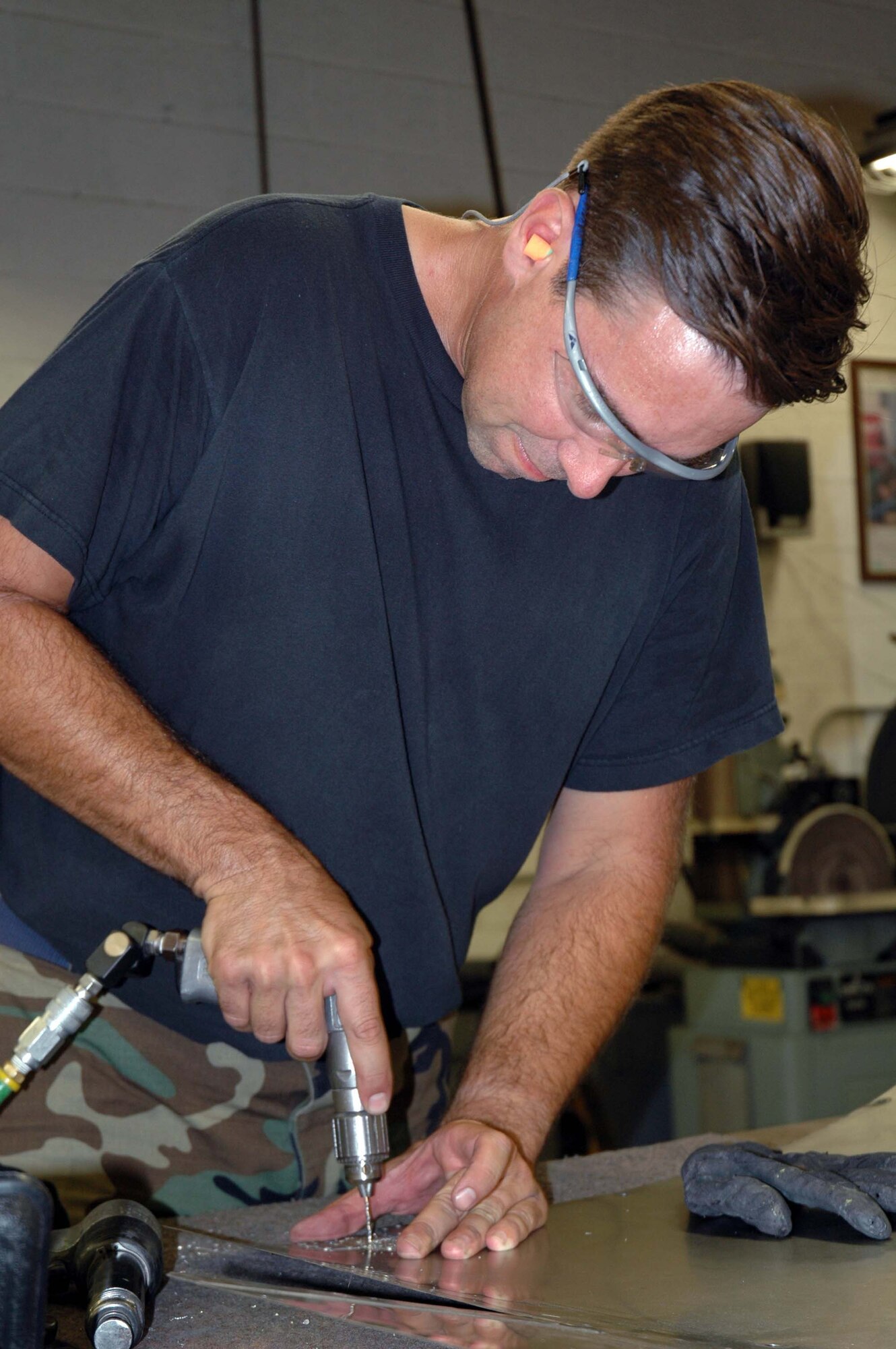 Staff Sgt. Mark Stair, 944th Maintenance Squadron structural maintenance technician, rivets a patch for a heat shield. The shop uses titanium for the heat shields because it can withstand high temperatures. (U.S. Air Force photo/Staff Sgt. Susan Stout)