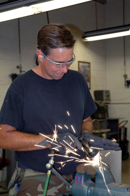 Staff Sgt. Mark Stair, 944th Maintenance Squadron structural maintenance technician, refines a piece of titanium which will be grafted onto a heat shield. (U.S. Air Force photo/Staff Sgt. Susan Stout)