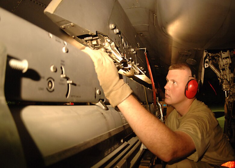 Staff Sgt. Stephen Hansen, an F-15E weapons loader with the 379th Expeditionary Aircraft Maintenance Squadron, guides a weapons carriage into place beneath an F-15E Strike Eagle Oct. 5.  The aircraft was about to fly the first combat sortie using the GBU-39/B small diameter bomb. The weapons carriage holds four small diameter bombs capable of striking four separate targets. Sergeant Hansen is deployed from Royal Air Force Lakenheath, England. (U.S. Air Force photo/Senior Airman Ricky Best)
