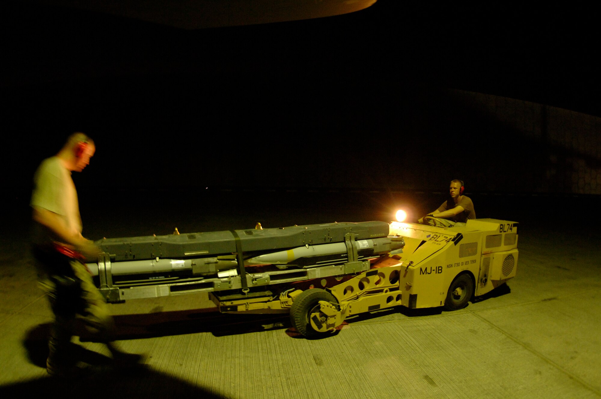 Weapons loaders from the 379th Expeditionary Aircraft Maintenance Squadron move a weapons carriage with GBU-39/B small diameter bombs attached to an F-15E Strike Eagle for uploading. The jet flew the first sortie into combat carrying the new munition Oct 5. The Airmen are deployed from Royal Air Force Lakenheath, England. (U.S. Air Force photo/Senior Airman Ricky Best) 