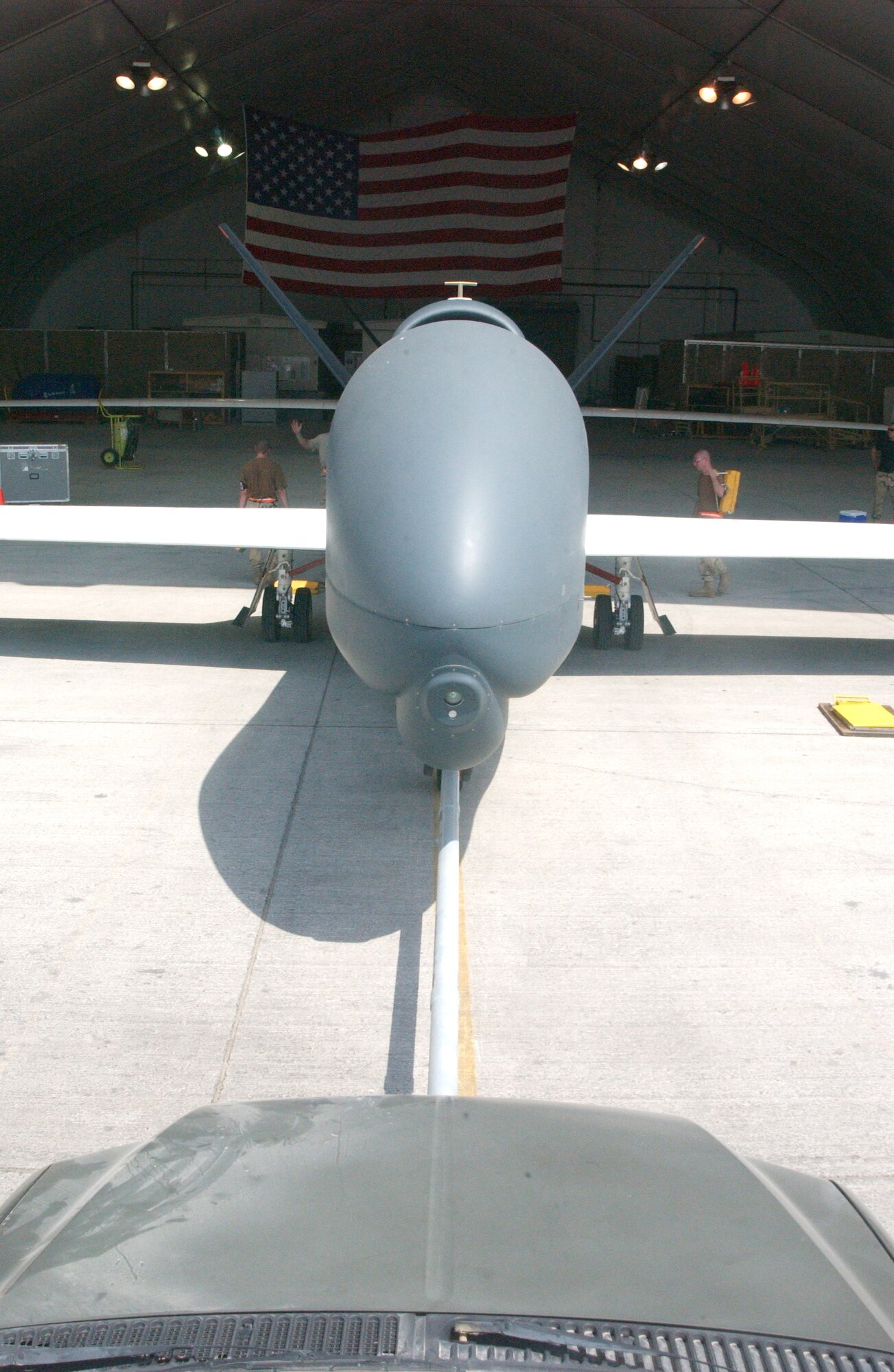 Crews from the 12th Expeditionary Reconnaissance Squadron and 380th Expeditionary Maintenance Group push a Global Hawk unmanned aerial vehicle into its hangar after a mission Oct. 3 at a deployed location in Southwest Asia. The Global Hawk provides Air Force and joint battlefield commanders near-real-time, high-resolution, intelligence, surveillance and reconnaissance imagery. (U.S. Air Force photo/Master Sgt. Jason Tudor)