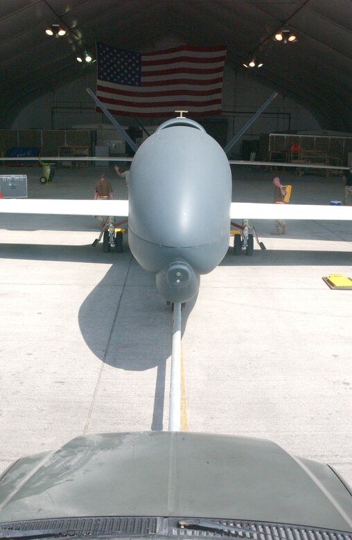 Crews from the 12th Expeditionary Reconnaissance Squadron and 380th Expeditionary Maintenance Group push a Global Hawk unmanned aerial vehicle into its hangar after a mission Oct. 3 at a deployed location in Southwest Asia. The Global Hawk provides Air Force and joint battlefield commanders near-real-time, high-resolution, intelligence, surveillance and reconnaissance imagery. (U.S. Air Force photo/Master Sgt. Jason Tudor)