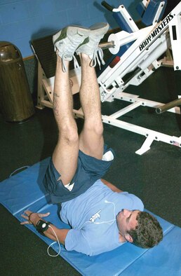 Staff Sgt. Joe Daly, 77th Aircraft Maintenance Unit electrical environment specialist, demonstrates how to properly perform hip raises. (U.S. Air Force photo/Senior Airman John Gordinier)
