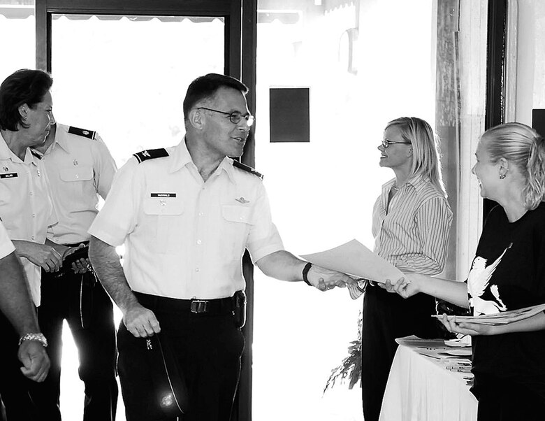 Col. John McDonald, 43rd Airlift Wing vice commander, is greeted at the entrance of the Pope Club Tuesday by volunteers of the United Way and other organizations designed to provide to help to those in need. The colonel attended the 2006-2007 Combined Federal Campaign Kickoff Luncheon which runs Tuesday through Nov. 14. (U.S. Air Force photo/Mike Murchison)
