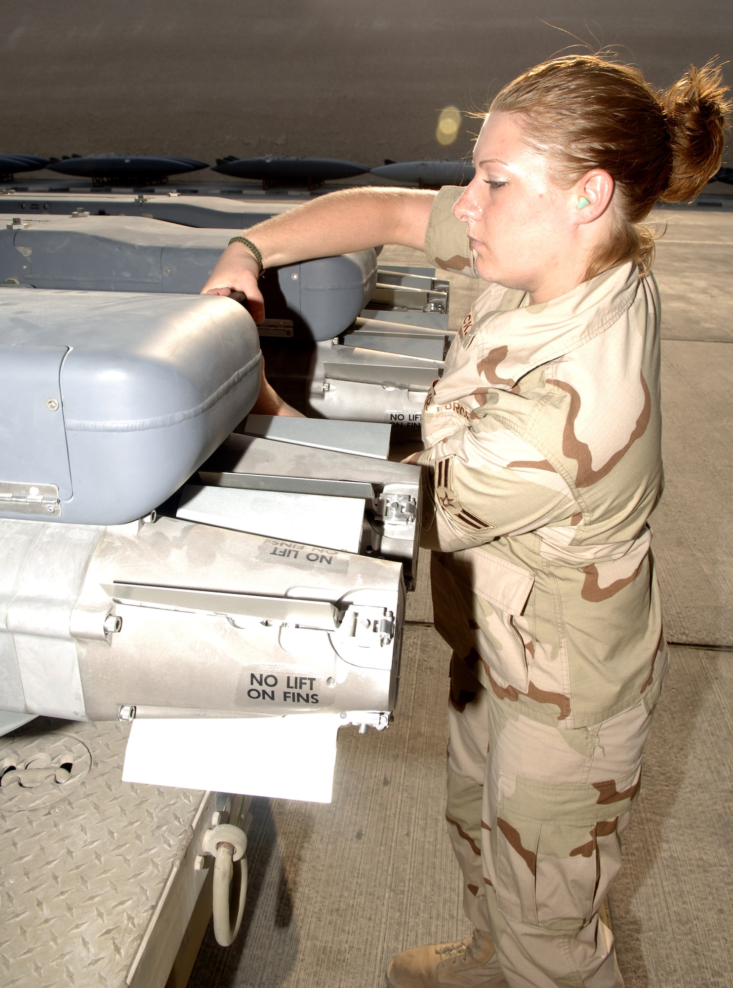 Airman 1st Class Amanda Hicks prepares a weapons carriage with GBU-39/B small diameter bombs to be uploaded on an F-15E Strike Eagle. Airman Hicks is assigned to the 379th Expeditionary Aircraft Maintenance Squadron and is deployed from Royal Air Force Lakenheath, England. (U.S. Air Force photo/Senior Airman Ricky Best)
