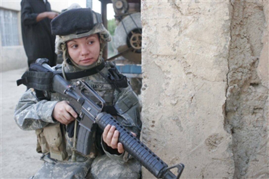 U.S. Army Spc. Jennie Baez provides security for fellow soldiers during an operation in the Al Anbar province of Iraq on Sept. 27, 2006.  Baez is assigned to the 47th Force Support Battalion.  