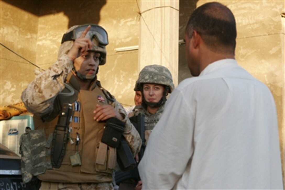 An interpreter for 2nd Battalion, 6th Infantry Regiment gathers information from Iraqi citizens during a mission to root out insurgent forces in the Al Anbar province of Iraq on Sept. 27, 2006.  