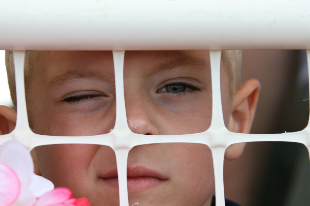 Carter Wilson, 6, looks through a fence for his father?s plane. Sgt. Adam Wilson returned Oct. 5 with fellow Marines with 3rd Battalion, 3rd Marine Regiment, from a seven-month deployment to Iraq in support of Operation Iraqi Freedom.