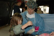Kellyann Rhyne, daughter of Lt. Col. Robert Rhyne, removes a candy bone during a 'surgery' during Travis Air Force Base's Kids Understanding Deployment Operations event Oct. 4. Mock surgeries were of many demostrations designed to give children an understanding of deployments. More than 300 children took part in the event. (U.S. Air Force photo by Jennifer Brugman/60th AMW Public Affairs)