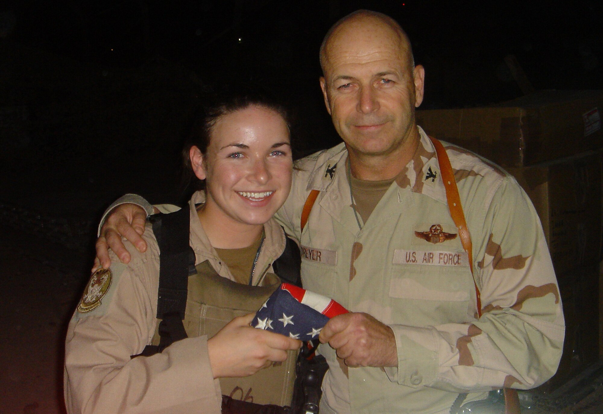 Col. Steven Dreyer, 4th Expeditionary Air Support Operations Group commander at Camp Victory, Iraq, presents his youngest daughter, 1st Lt. Kathrine Dreyer, 777th Expeditionary Airlift Squadron at Balad Air Base, Iraq, with the family flag.  Lieutenant Dreyer is a C-130 Hercules navigator deployed from the 50th Airlift Squadron at Little Rock Air Force Base, Ark. (Courtesy photo)