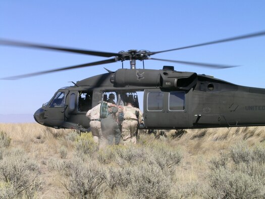 Survival, Evasion, Resistance and Escape specialists assist a simulated downed aircrew into a Black Hawk helicopter during Combat Survival Training near Mountain Home Air Force Base. (Courtesy photo)