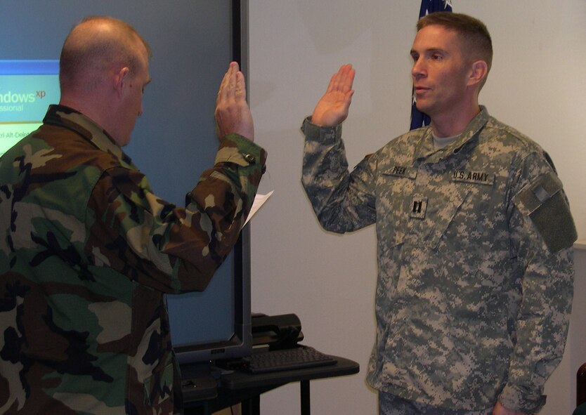 Capt. Darrell E. Peek, formerly assigned to Air Force Special Operations Command Security Forces Directorate, was commissioned into the US Army by Lt. Col. Erik Rundquist, AFSOC SF chief, Sep. 25. (U.S. Air Force Photograph by Master Sgt. Mike Smith)