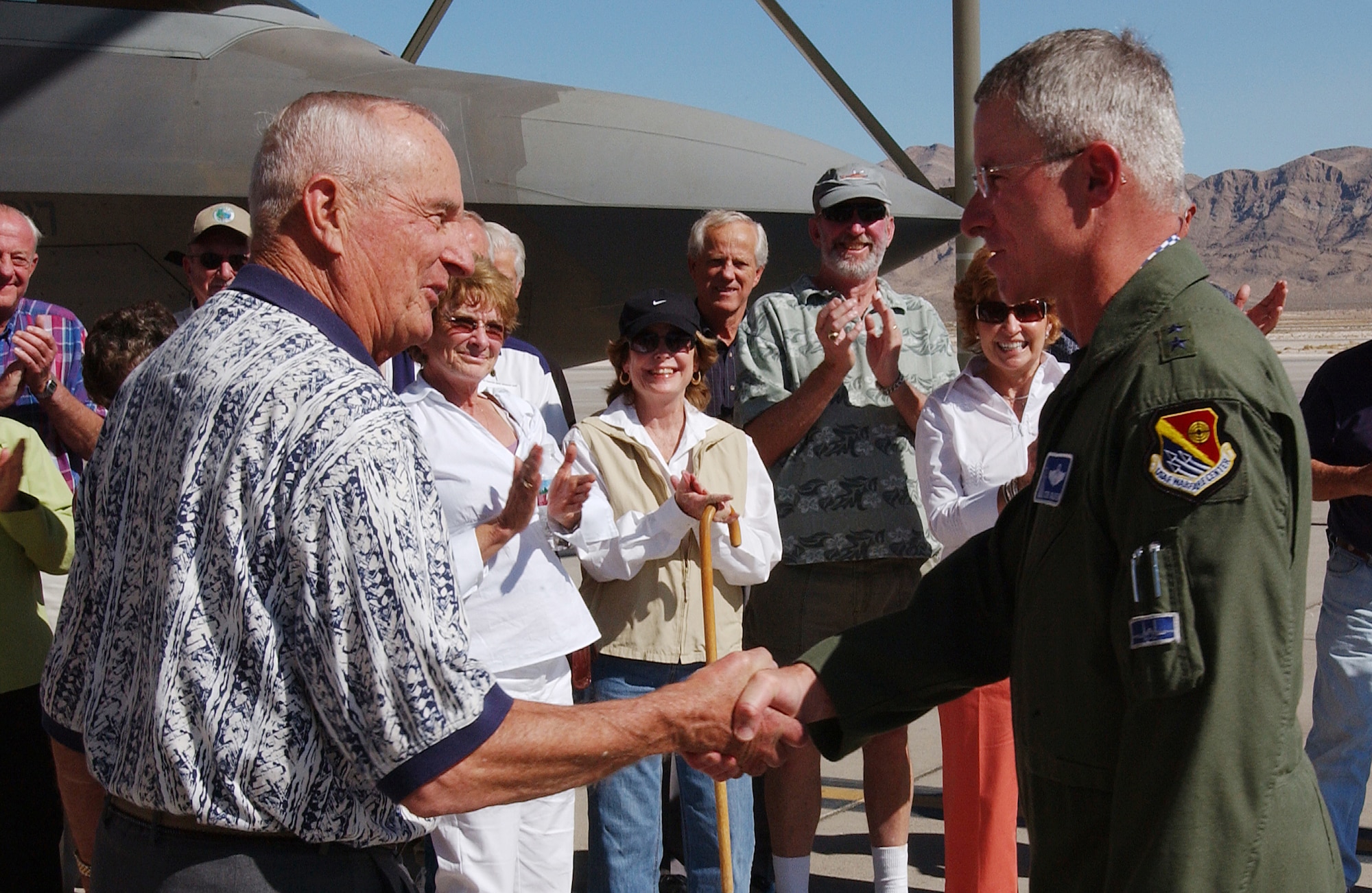 Retired Lt. Gen. Winfield "Skip" Scott (left) of the 48th Tactical Fighter Wing reunion group thanks Maj. Gen. Stephen Goldfein, U.S. Air Force Warfare Center outgoing commander, for a great tour. An F-22A Raptor is in the background. (U.S. Air Force photo/Airman 1st Class Kasabyan Austin)