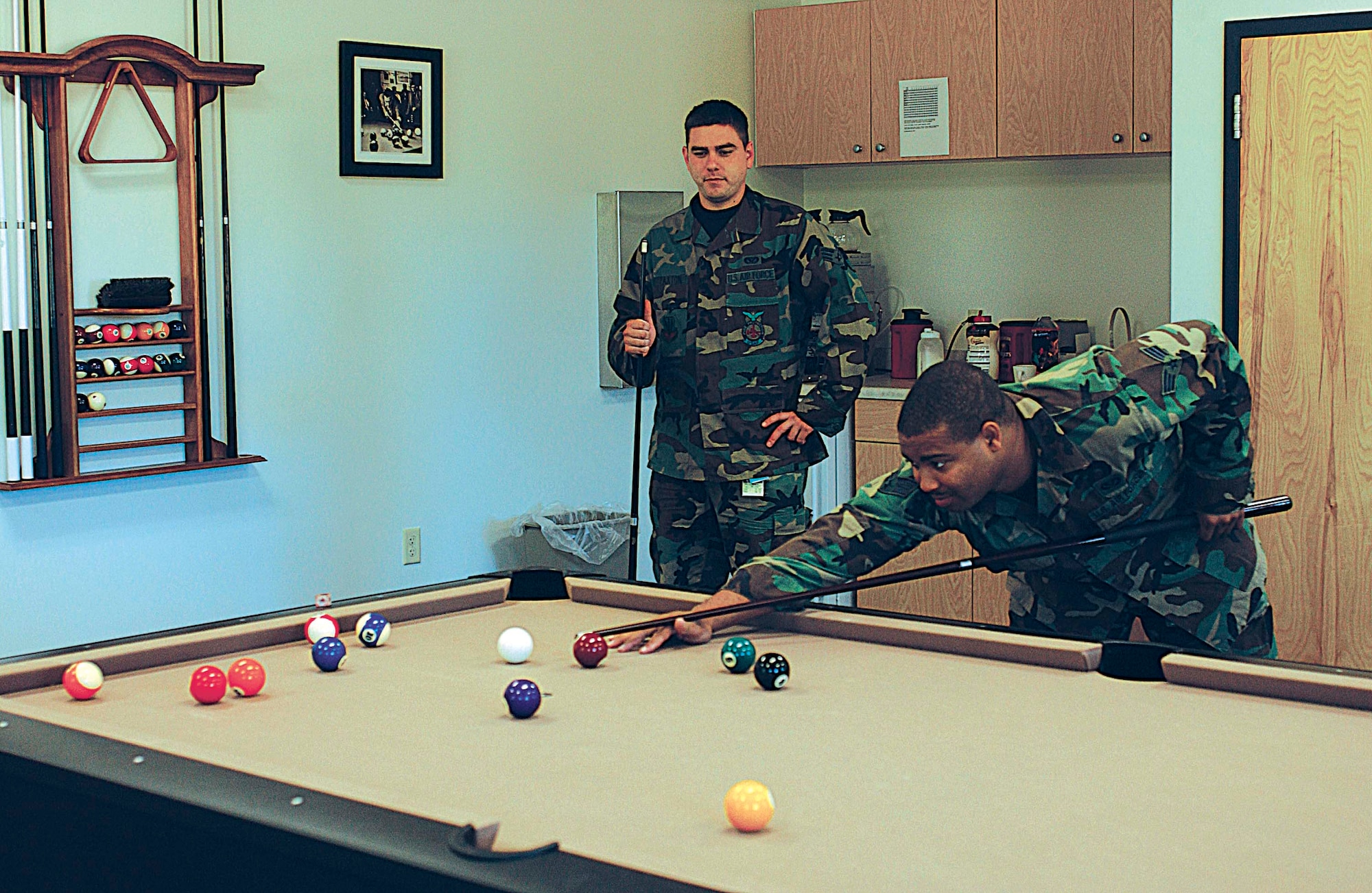 Senior Airmen Travis Paxton (left) and Garcia Tarver, both firefighters from the 4th Civil Engineer Squadron, play pool in the recreation room at the new fire station here Monday. The new station's amenities make life and work more bearable for the firefighters who are on duty for 24-hour shifts.  (Photo by Staff Sgt. Shawn J. Jones)                          