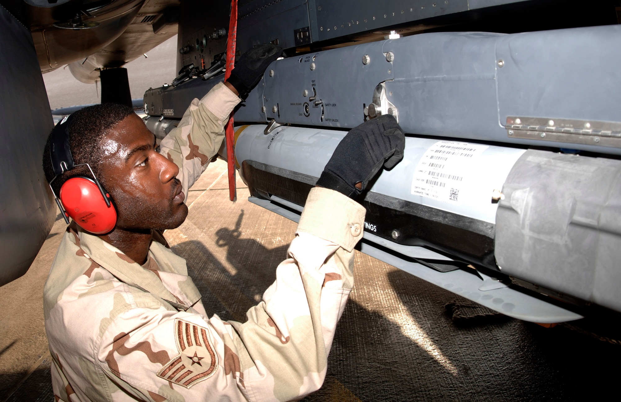 Staff Sgt. Kevin Harvey secures a weapons carriage with GBU-39/B small diameter bombs to an F-15E Strike Eagle. Sergeant Harvey is assigned to the 379th Expeditionary Aircraft Maintenance Squadron. (U.S. Air Force photo/Senior Airman Ricky Best) 
