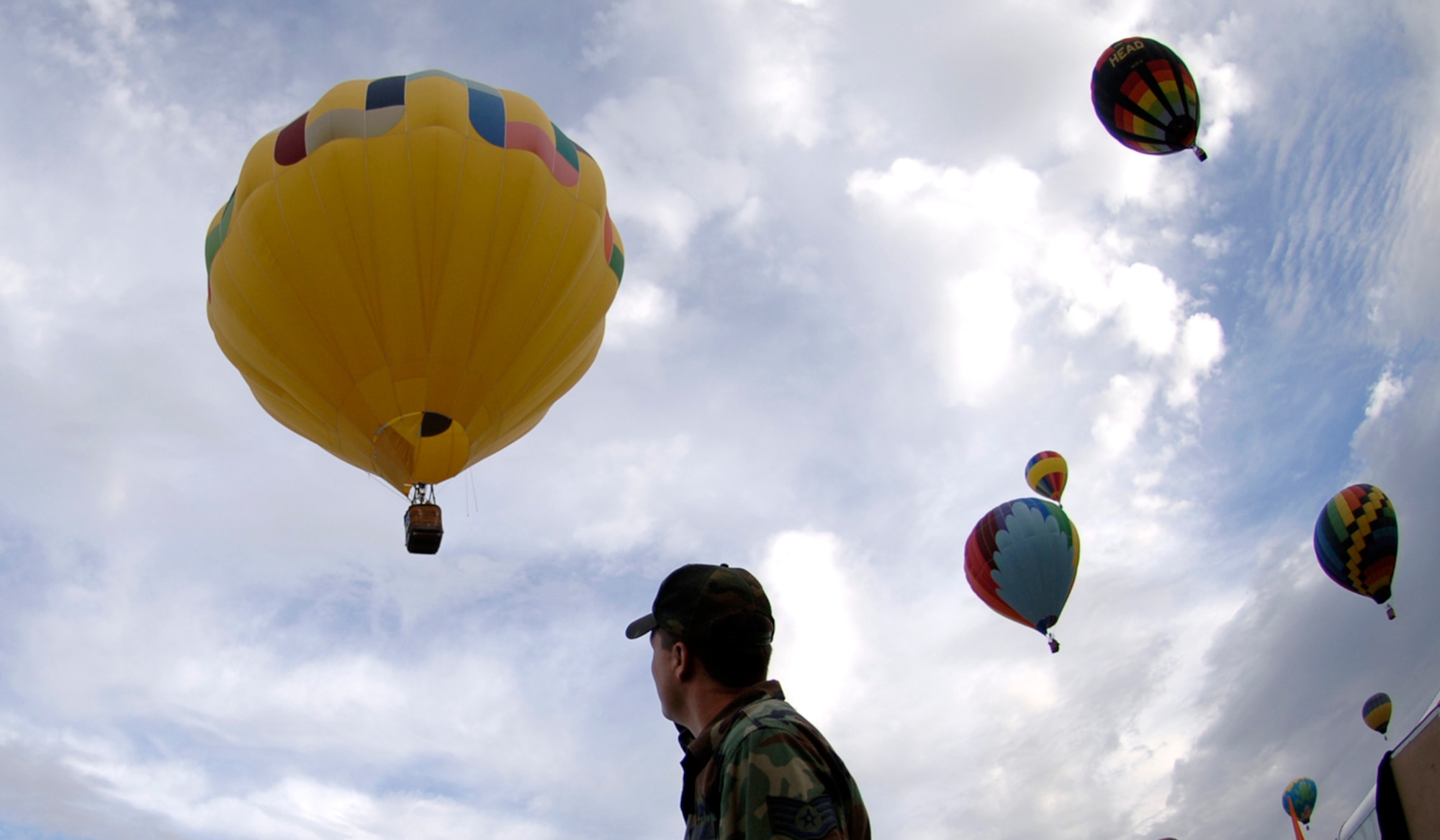 An Air Force member watches as the first of 700 hot air balloons took off for the first mass ascension over Fiesta Park during the Balloon Fiesta at Albuqerque, New Mexico, Oct. 7, 2006.   Balloon Fiesta is a world-renowned New Mexico attraction where several hot air balloons have been flying for thirty five years.  (US Air Force photo/Tech Sgt. Cecilio Ricardo Jr.)