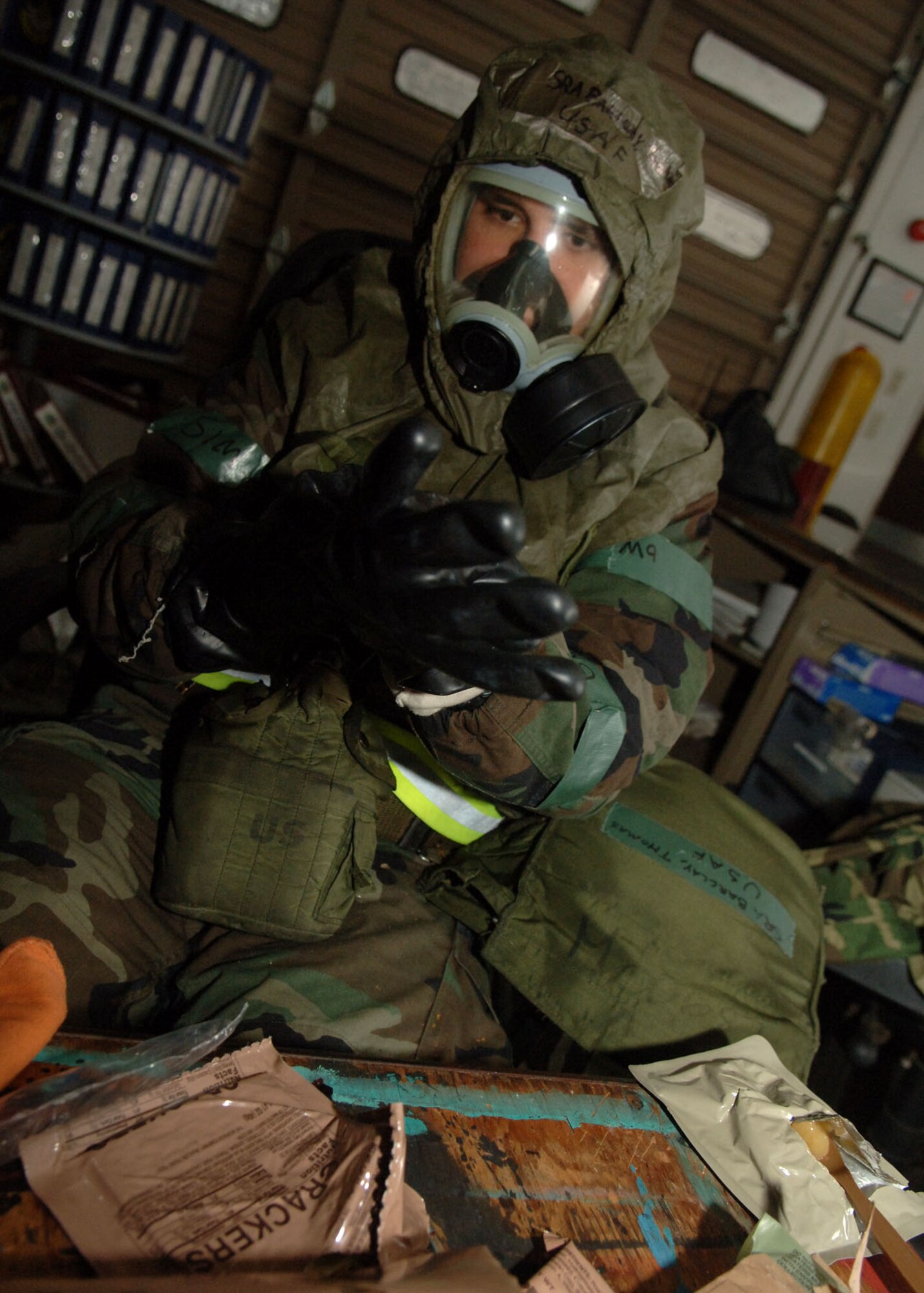 Senior Airman Thomas Barclay suits up for a mission-oriented protective posture 4 during a simulated alarm red attack at Yokota Air Base, Japan, during a 374th Air Wing exercise. MOPP levels relate to chemical or biological hazards.  Airman Barclay is with the 374th Maintenance Squadron.  (U.S. Air Force photo/Senior Airman Veronica Pierce)