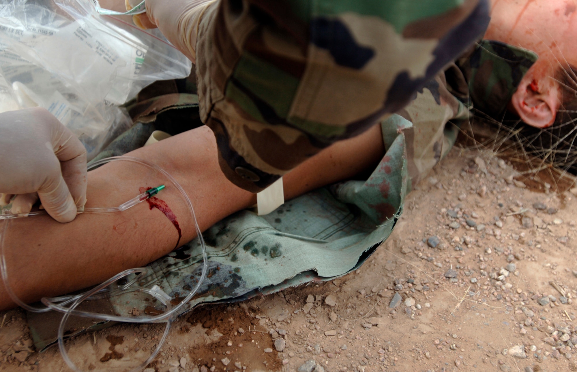 Pararescue trainees insert an intravenous catheter while performing life-saving techniques on simulated casualties during an exercise at Kirtland Air Force Base, N.M., Oct. 6. The exercise is part of the pararescue recovery specialist course at the Pararescue and Combat Rescue Officer School. (U.S. Air Force photo/Tech. Sgt. Cecilio Ricardo Jr.)