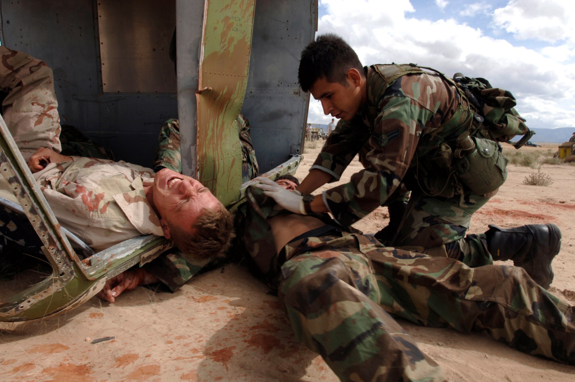 Airman 1st Class Kevin Freyre inspects Airman 1st Class Nathan Greene for injuries while another simulated patient yells in pain during a mass casualty incident exercise at Kirtland Air Force Base, N.M., Oct. 6. The exercise is part of the pararescue recovery specialist course at the Pararescue and Combat Rescue Officer School. (U.S. Air Force photo/Tech. Sgt. Cecilio Ricardo Jr.)