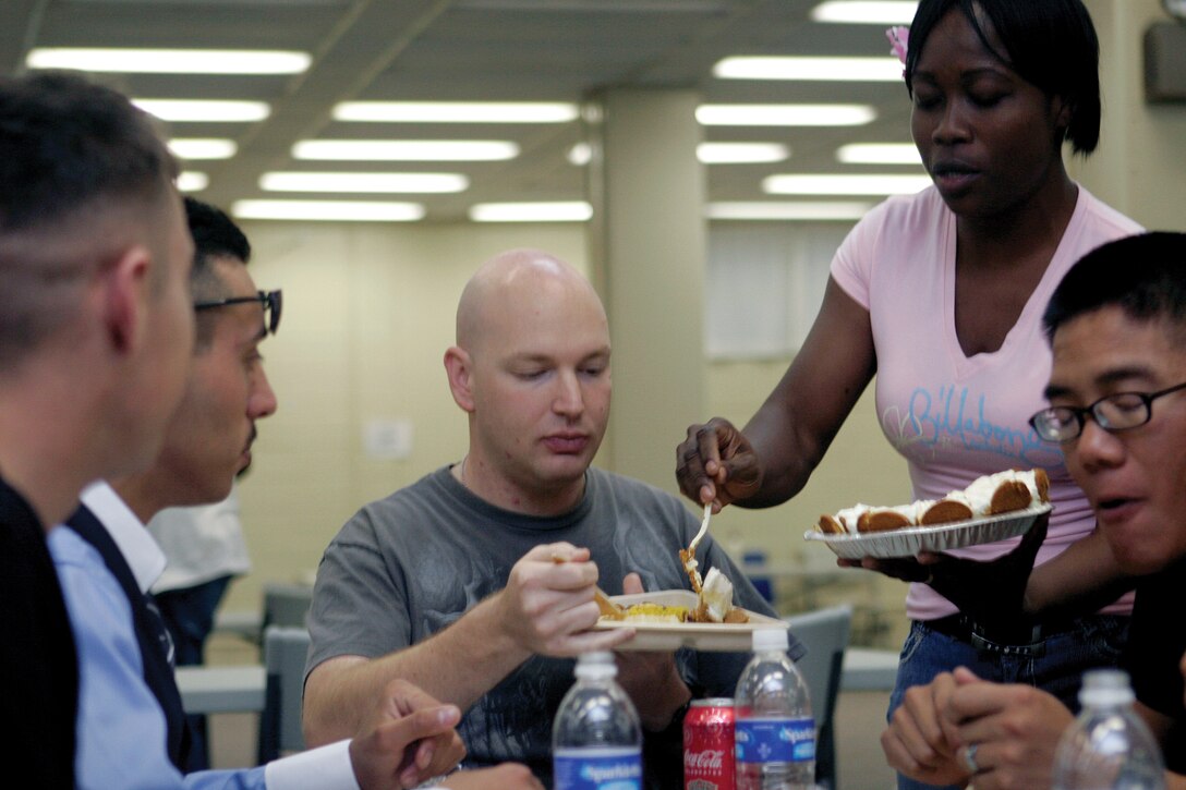 Staff Sgt. Carla Arana, a food service specialist with Food Service Company, Combat Logistics Regiment 37, 3rd Marine Logistics Regiment, III Marine Expeditionary Force, serves a slice of pie to Sgt. Stephen Wallace, a radio technician with Communications Company, CLR-37, during the Taste of Home hosted by the Unit and Family Readiness Office on Camp Kinser May 17.