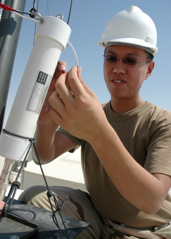 Sgt. Barry Lim, a Singaporean communications specialist, sets up a new antenna designed to double the distance the Singaporean Air Force can communicate with its aircraft from the ground. (Photo by Maj. Ann P. Knabe)
