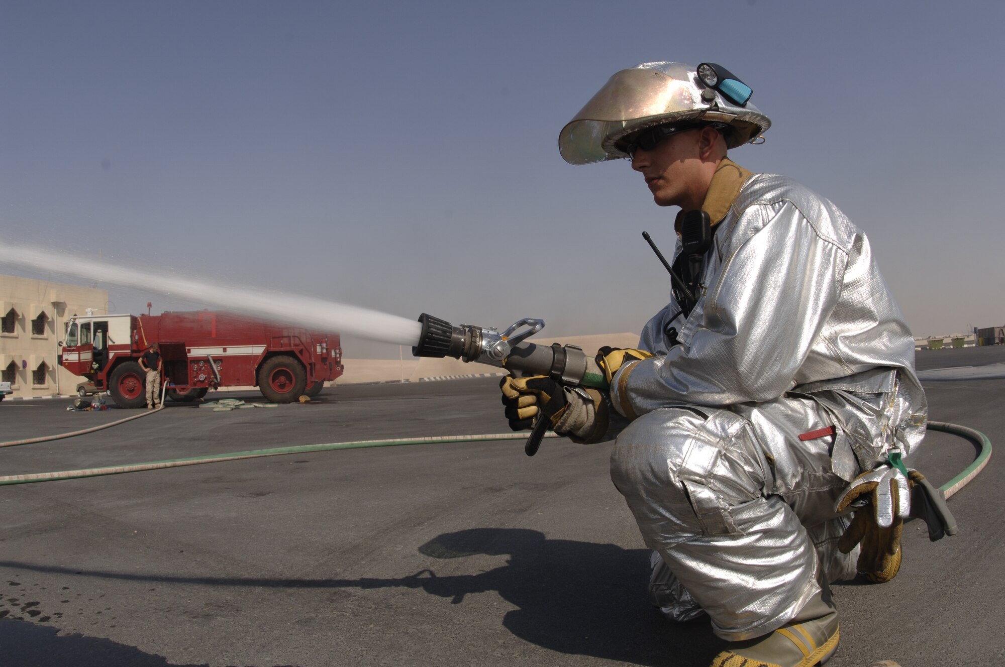 Senior Airman Michael Pullman sprays water during a fire training exercise Oct. 5 in Southwest Asia. Airman Pullman is deployed to the 379th Air Expeditionary Fire Department. (U.S. Air Force photo/Senior Airman Ricky Best)