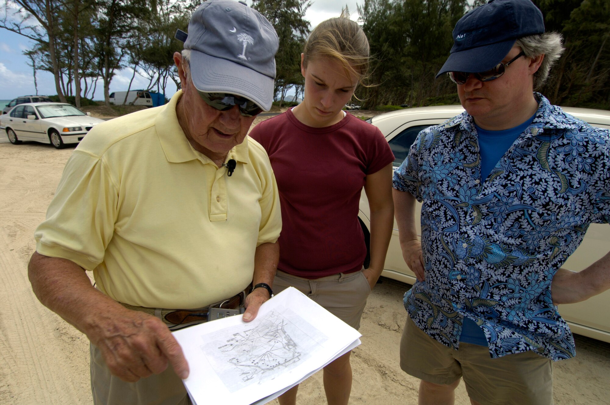 Raymond Stehle; his granddaughter, Sheila McQueen; and son, Vincent Stehle, look over a historical map of Oahu at Bellows Air Force Station, Hawaii, Sept. 30. Mr. Stehle was stationed at  Bellows Army Air Field when the Japanese attacked on Dec. 7, 1941. (U.S. Air Force photo/Tech. Sgt. Shane A. Cuomo) 