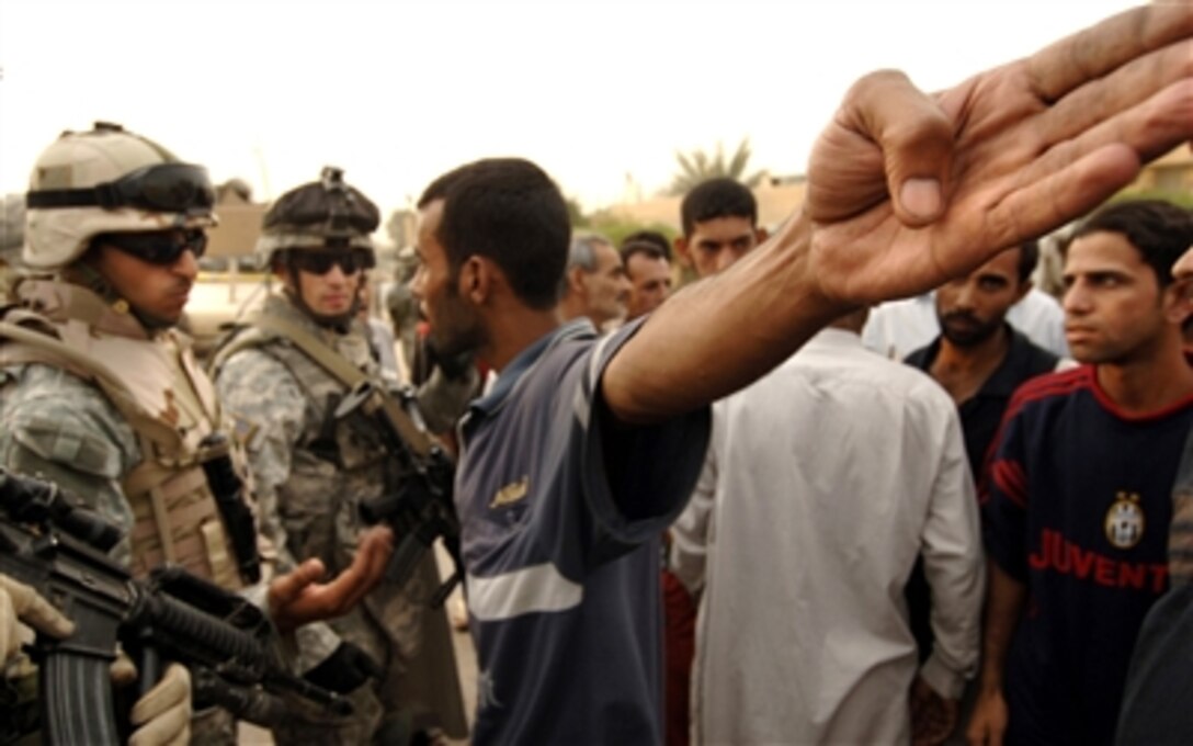 An Iraqi man, who is angry about crime in his neighborhood, explains to an interpreter and U.S. Army soldiers from 1st Squadron, 61st Cavalry Regiment, 506th Regimental Combat Team, 101st Airborne Division, details of recent criminal activity in the Shaab neighborhood of northeast Baghdad, Iraq, Oct. 2, 2006. 