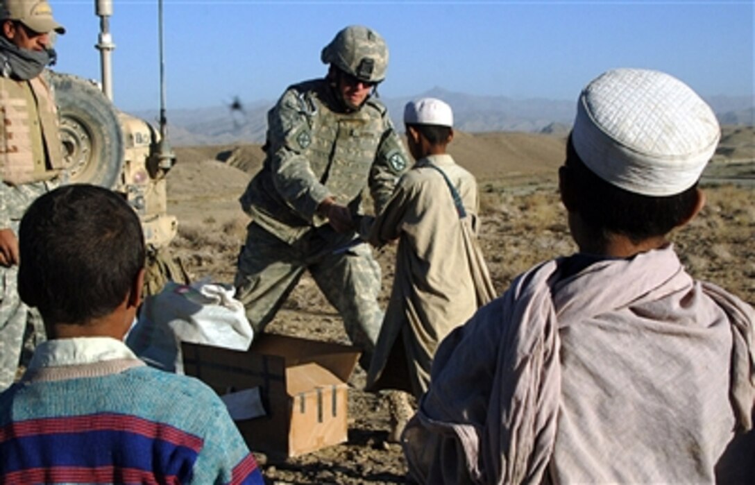 U.S. Army 1st Lt. Dan Gordon, from Headquarters Platoon, Bravo Company, 2nd Battalion, 87th Infantry Regiment, 10th Mountain Division, gives school supplies to Afghan children in Gomal, Afghanistan, Oct. 4, 2006. The supplies were donated by a school in North Dakota. 
