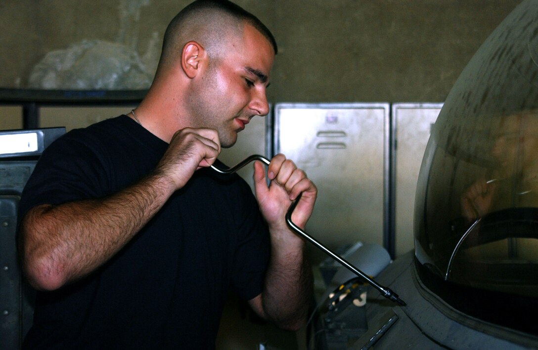Senior Airman Mike Fire tightens a screw to an F-16 Fighting Falcon canopy Oct. 10 at Balad Air Base, Iraq. Airman Fire is assigned a 332nd Expeditionary Maintenance Squadron aircrew egress systems craftsman deployed from Hancock Field Air National Guard Base in Syracuse, N.Y. (U.S. Air Force photo/Staff Sgt. Alice Moore)
