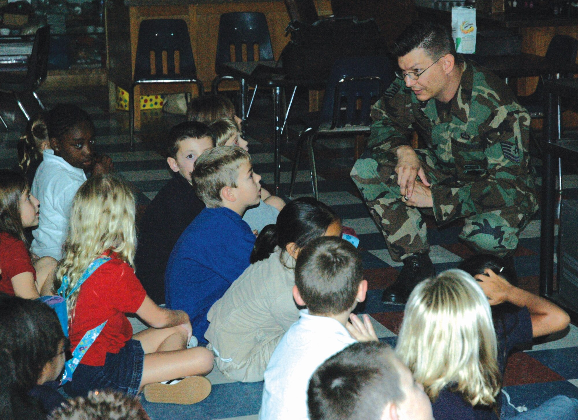 Tech. Sgt. Publio Casillas answers individual students' questions after his presentation on weather Sept. 28 at Tyndall Elementary School in Florida. Sergeant Casillas is the NCO in charge of the 325th Operations Support Squadron Weather Flight mission services element at Tyndall Air Force Base, Fla. (U.S. Air Force photo/Chrissy Cuttita) 