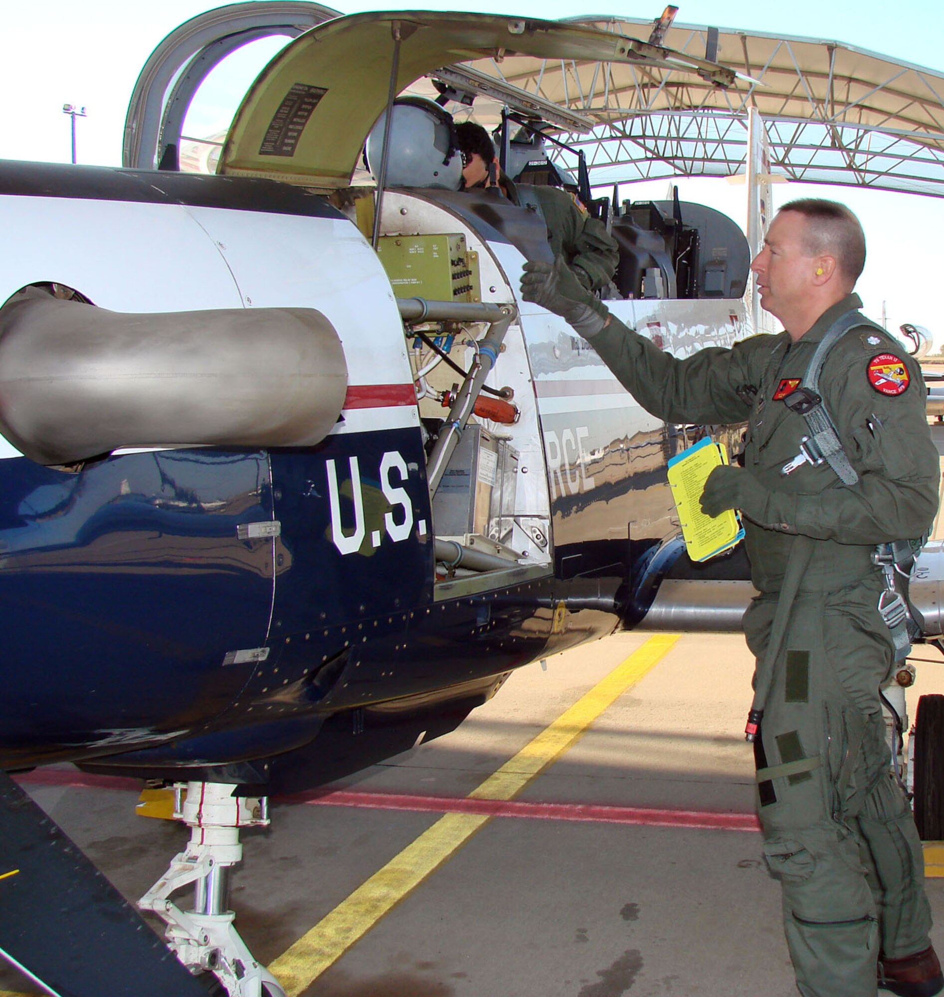 Navy Cmdr. Todd Rader preflights a T-6 Texan II aircraft Oct. 4 at Vance Air Force Base, Okla., prior to a training mission.  Commander Rader, the 8th Flying Training Squadron commander, currently is the only active-duty U.S. Navy officer serving as an Air Force squadron commander in the Air Education and Training Command.  Commander Rader took command of the 8th FTS in June and carries on a tradition of having a Navy officer rotate every other year as commanding officer of the unit.  (U.S. Air Force photo/Capt. Tony Wickman)