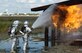 McGuire fire fighters, Airman 1st Class Jesse Crespo (front) and Dominick Severino, extinguish a fire on the number four engine of the base aircraft trainer. Photo courtesy of the base multimedia shop