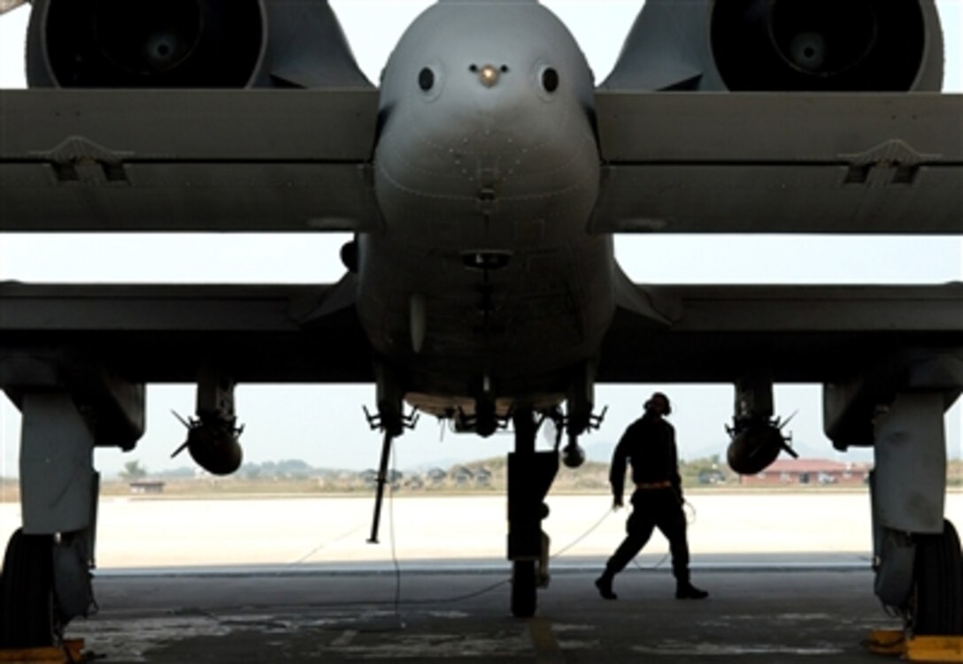 A U.S. Air Force crew chief does a safety check on an A-10 Thunderbolt II aircraft before taking off for a sortie during a full spectrum threat response on Osan Air Base, South Korea, Sept. 27, 2006.  